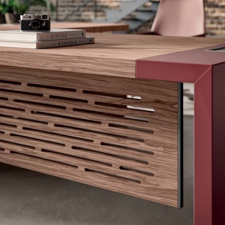 E10 Executive Desk & Return with veneered top, leather inlays, and carved modesty panel, showcasing a bold, L-shaped design.