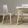 FJORD Chair with white polypropylene shell and wooden legs, featuring a beige seat, beside a table in a modern setting.