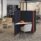 Oasis Floor Standing Screen in black with orange accents creates a private work zone for a desk and chair in an office setting.