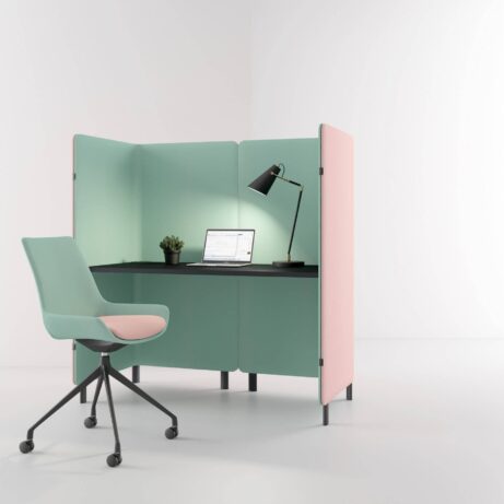 Oasis Screens in green and pink create a modular workspace with acoustic privacy, featuring a desk and rolling chair.