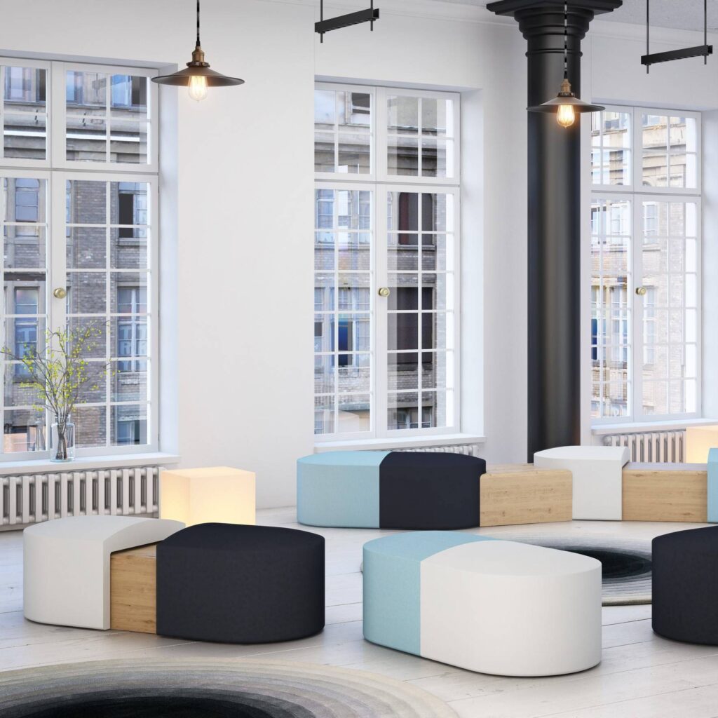 Modular PILL seating in varied colors with integrated concealed tables, arranged for flexible breakout or reception spaces.